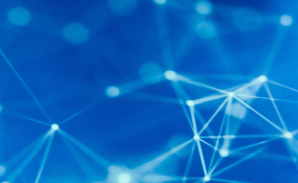 Futuristic robotic hand touching a digital network on a blue background.